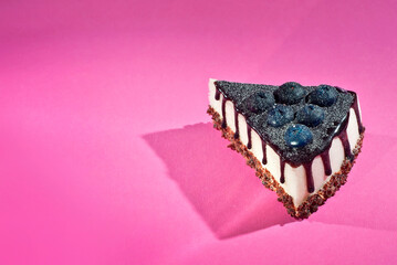 Cake with athens on a pink background. Triangular piece of cake on a paper background. Sweets close up.