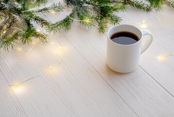 Obraz na płótnie Canvas Christmas coffee in a white cup and new year decoration on wooden background