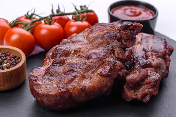 grilled beef steaks with spices on a dark cutting board