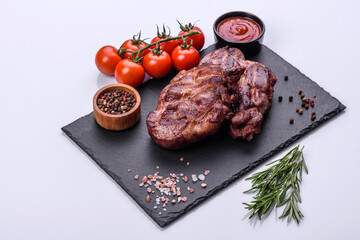 grilled beef steaks with spices on a dark cutting board