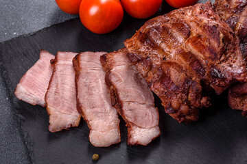 grilled beef steaks with spices on a dark cutting board