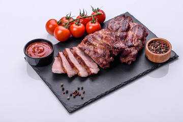 grilled beef steaks with spices on a dark cutting board