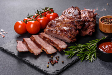 grilled beef steaks with spices on a dark cutting board