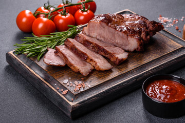 grilled beef steaks with spices on a dark cutting board