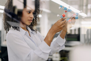 Businesswoman examining molecules model in industry