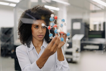 Female entrepreneur examining molecule in industry