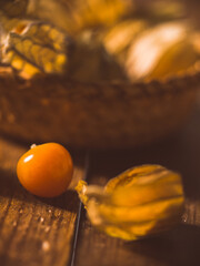 tropical fruit, physalis, from very close next to a basket with more fruits, colorful photography on wooden table