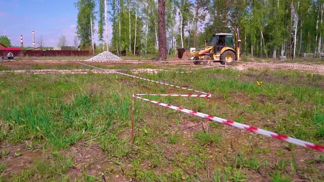 The tractor levels the ground. Production of works by a bulldozer. Preparation of the construction site.