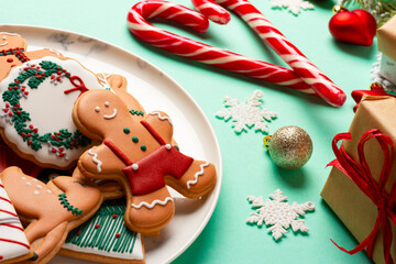 Christmas composition with decorations and cookies on a mint background
