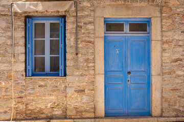 Obraz na płótnie Canvas Greek house with blue door and window on Symi island in Greece