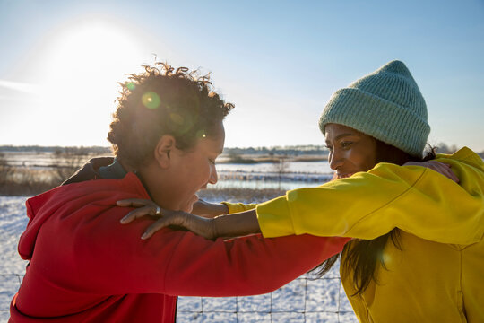 Cheerful mother and son playing together during winter