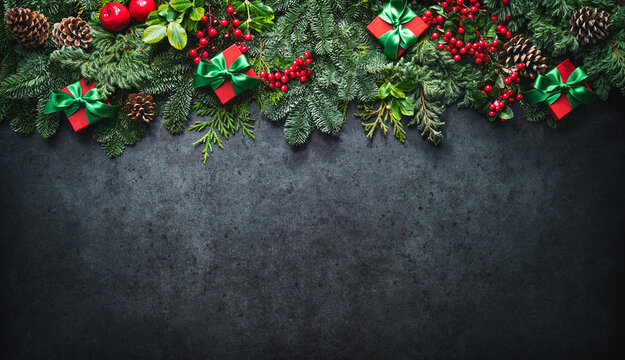 Christmas background with pine branches, berries, decorations and gift boxes
