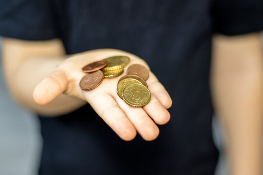 euro cents on grey background or kid child hand palms counting.old wiped coins instead of pills in bottle.finance savings, business.one, two,ten and fifty euro cents. space for text.tables cost money