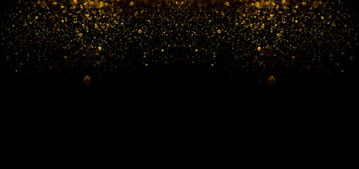 golden glittering star magic gold dust on black background. Particles on dark backdrop.  yellow...