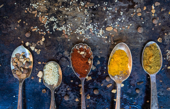 Spoons with various spices and legumes