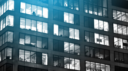 Obraz premium Big glass windows in commercial skyscraper at night. Black and white.