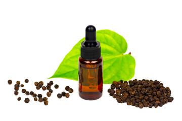 Black pepper essential oil in glass bottle with peppercorn and green leaf isolated on white...