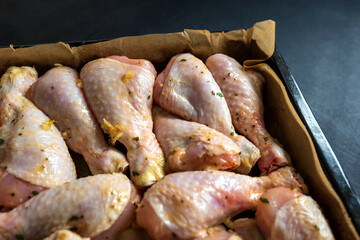 raw chicken drumsticks on baking tray prepared for oven