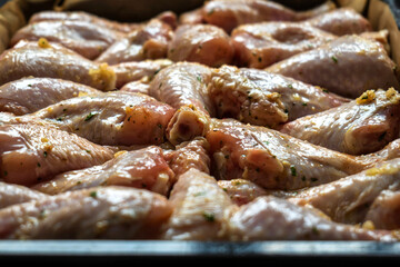 raw chicken drumsticks on baking tray prepared for oven