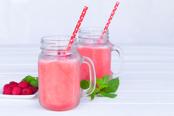 Raspberry smoothie red colorful fruit juice milkshake blend beverage healthy high protein the taste yummy In glass drink episode morning on white wood background.
