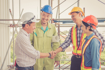 Engineer and worker team making handshake together to agree joint business at construction site.