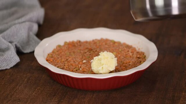 Woman Making Shepherd's Pie. Mashed Potatoes Being Placed On Top Of Minced Meat.