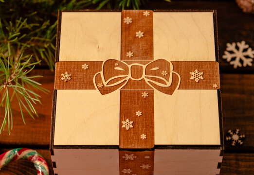 wooden box with an engraving of a bow and ribbon on the lid