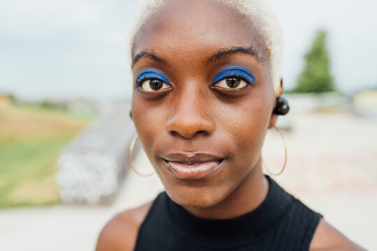 Young woman with blue eyeshadow staring