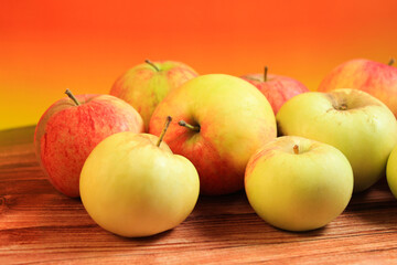 red and yellow apples on an orange background. fruits, healthy lifestyle, healthy food