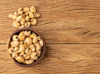 Canjica, hominy or white corn popcorn, sweet popcorn in a bowl over wooden table with copy space