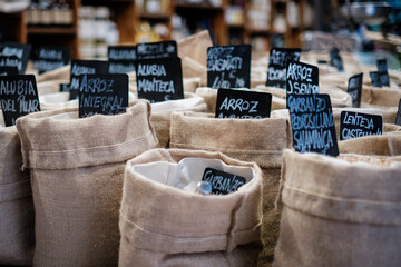 Sacks of rice for sale in a market with a slate sign