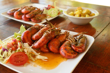 Barbeque seafood with green salad meal on wooden table