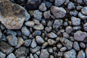 The background is made of textured rubble, gray. The texture of pieces of gray blast furnace slag....