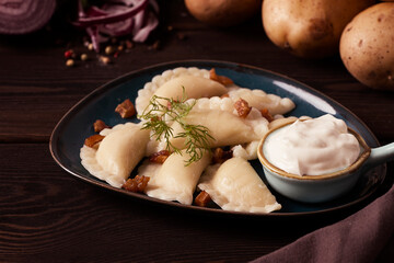 Traditional Polish dish, dumplings with potatoes, on a wooden table, close-up, with ingredients, no...