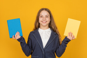 happy child presenting school book on yellow background, workbook