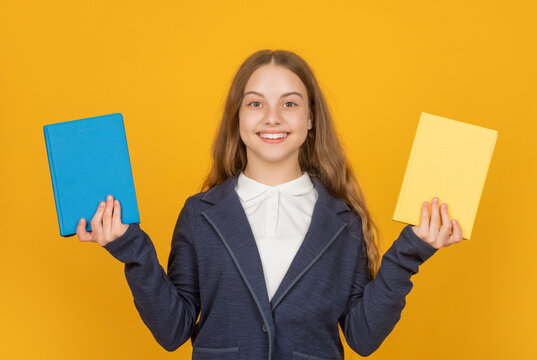 happy child presenting school book on yellow background, workbook