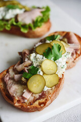 Roast beef, pickle and cheese with remoulade (danish tartar sauce) Smorrebrod. Danish open faced sandwich. Selective focus