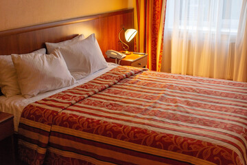 hotel bed interior with lamps in warm colors