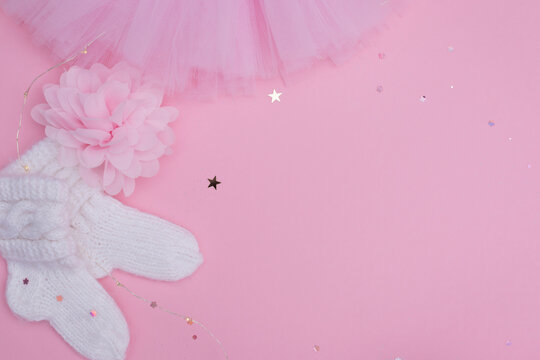Background of baby decor and  baby supplies on pink background. Top view decoration baby socks and tutut skirt with glitter stars.  Copy space for add text.