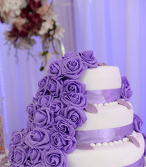 Wedding cake decorated with purple rose flowers
