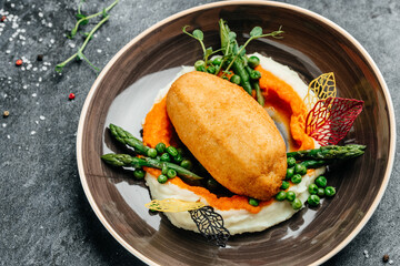 Slavic food. Cutlet in Kyiv style with mashed potatoes and pumpkin. decorated asparagus and peas. Food recipe background. Close up