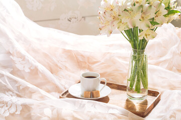 breakfast in bed with coffee and flowers on a tray. Romantic breakfast in bed.