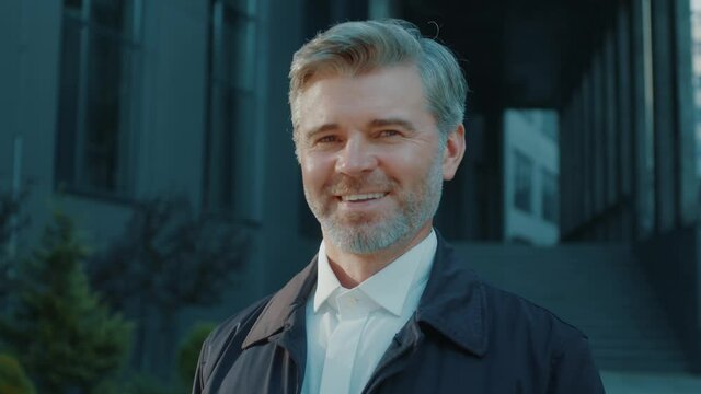 Portrait smiling adult mature businessman grey-haired office manager boss standing on sunny street smiling proudly. People and success. Career personality.
