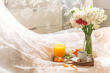 breakfast in bed with fruits, coffee and flowers on a tray. Romantic breakfast in bed