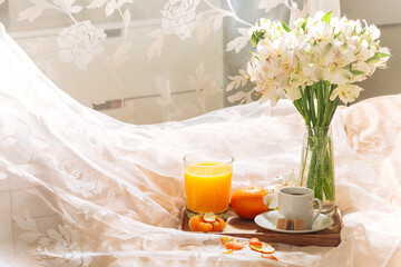 breakfast in bed with fruits, coffee and flowers on a tray. Romantic breakfast in bed