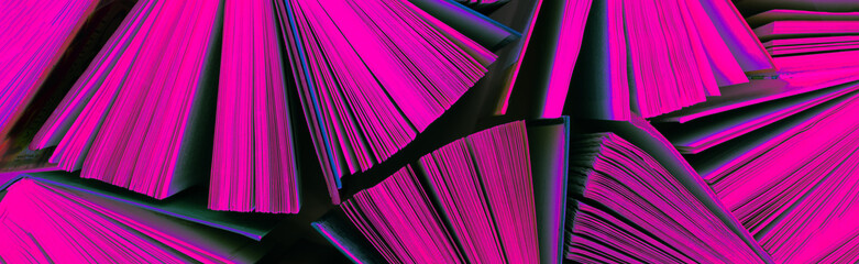 Many stacks of books tinted in neon light. Old hardback books as background. Back to school - obrazy, fototapety, plakaty