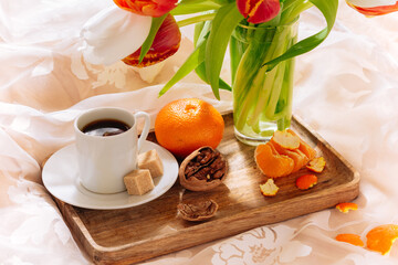 breakfast in bed with fruits, nuts, coffee and flowers on a tray. Romantic breakfast in bed