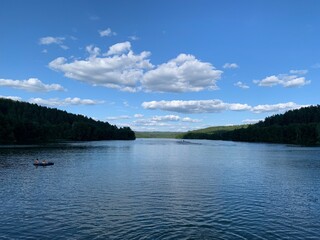 the calm expanse of Lake Yulovskoe surrounded by forest and greenery in summer