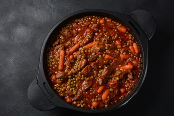 Beef stew, meat ragout with carrots, onions and green peas. Meat stew with vegetables in tomato sauce in a bowl.