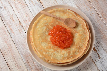 Pancakes with red caviar. Shrovetide Maslenitsa Week festival meal. Stack of Russian pancakes with red caviar. Rustic style